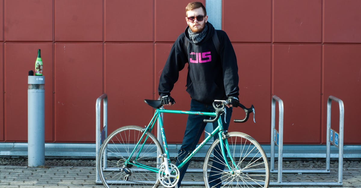 A man standing with his bicycle on a sunny day in L'viv, showcasing urban style and transportation.